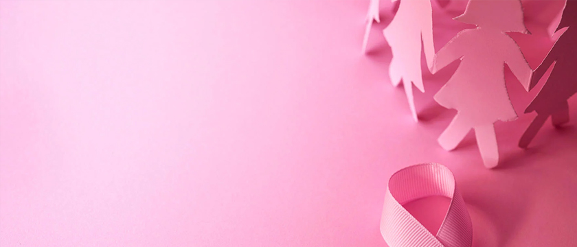 Pink breast cancer awareness ribbon with paper cutout figures of women